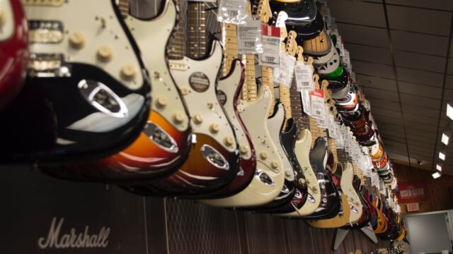 electric guitar hanging near wall